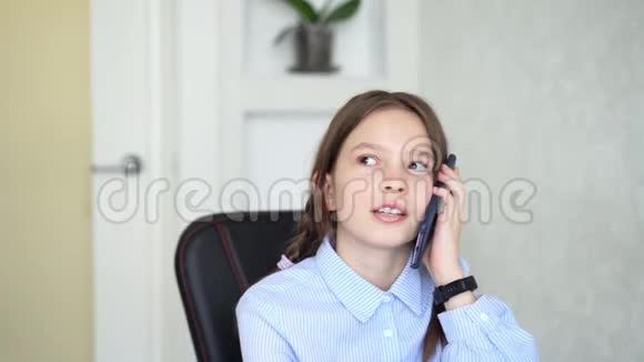 年轻女孩坐在家里用智能手机视频的预览图