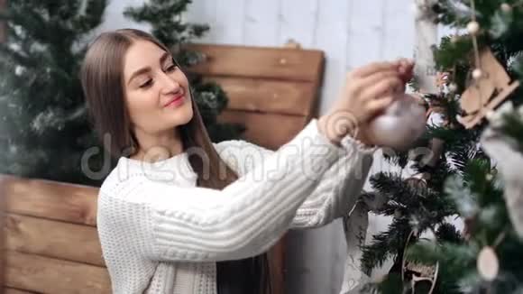 漂亮的女人把玩具球挂在圣诞树上中型近距离拍摄4k红色相机视频的预览图