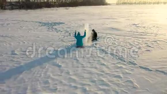 女孩和男孩互相扔雪在冬季公园里尽情享受冬天在公园散步他的笑声和欢乐视频的预览图