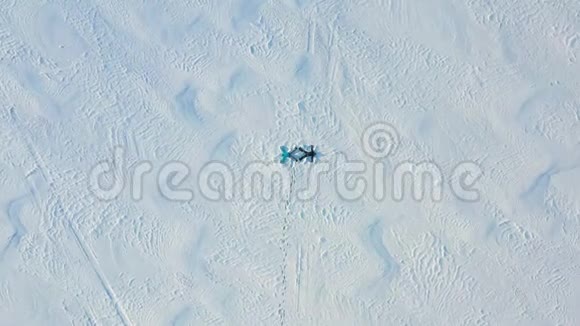一家人在森林的空地上做一个雪天使的身影一个女孩和一个男孩躺在空中摄影视频的预览图