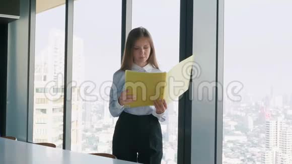 商务女性拿着文件夹窗口附近有城市景观视频的预览图