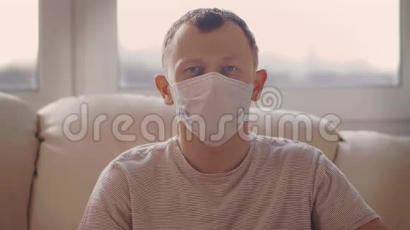 一个男人坐在沙发上摘下他的医疗面具流行病的结束视频的预览图