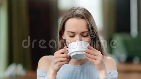 在咖啡馆里微笑着喝热茶的美女的肖像4k红色摄像机特写镜头视频的预览图