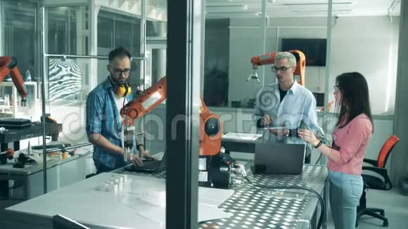 年轻的科学家正在测试一个机器人装置在创新实验室工作的年轻工程师视频的预览图