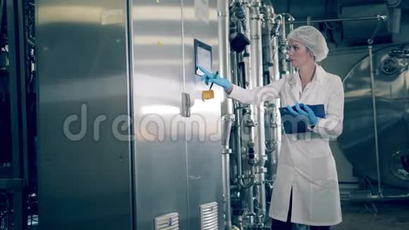 一位妇女正在通过控制面板操作工厂的机器视频的预览图