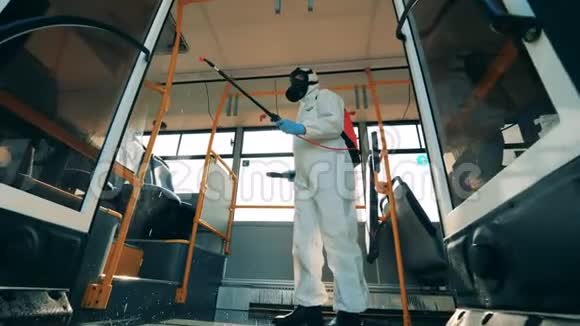 一个穿着防护服的人正在公共汽车上做化学处理视频的预览图