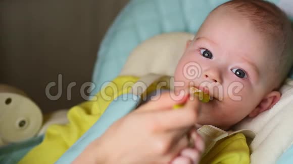 妈妈喂孩子母亲把一勺捣碎的东西放进孩子的嘴里小孩吃东西视频的预览图