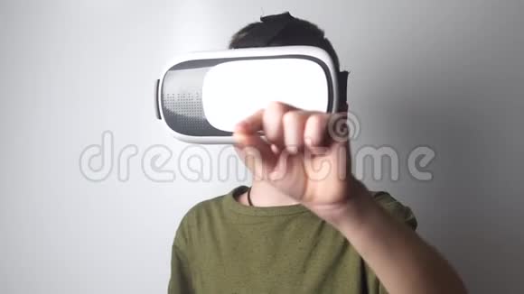 男孩在白色背景上使用虚拟现实耳机头盔虚拟现实虚拟现实眼镜新的高科技技术视频的预览图