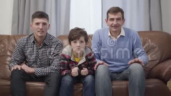 高加索多代球迷家庭在电视上观看比赛的肖像中年男子他成年的儿子视频的预览图