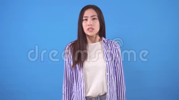 美丽的亚洲年轻女子牙痛蓝色背景视频的预览图