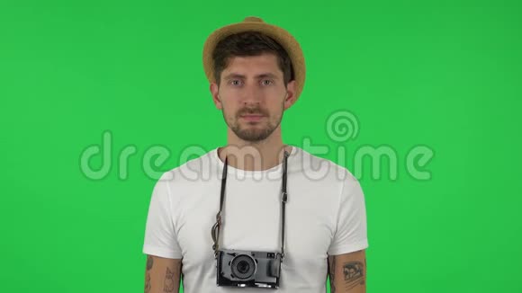 度假时戴帽子的游客画像用复古相机拍照绿色屏幕视频的预览图