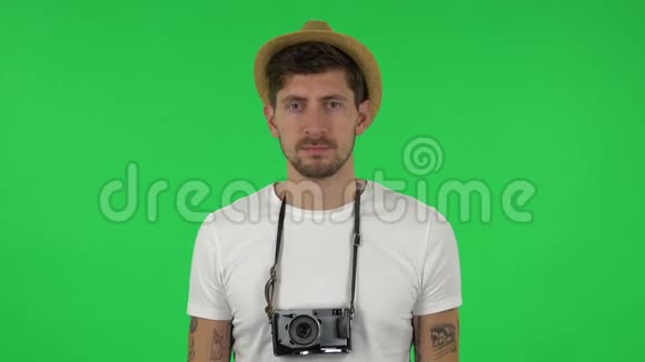 度假时戴帽子的游客画像用复古相机拍照绿色屏幕视频的预览图