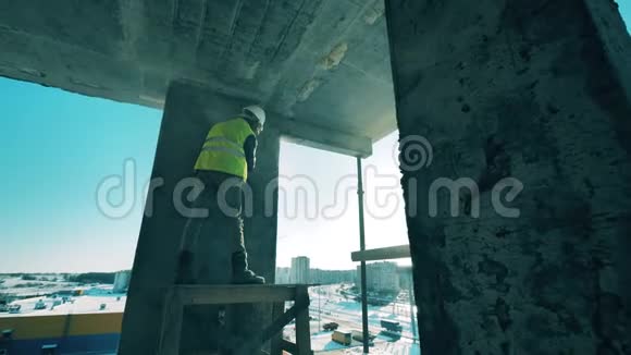 一个人在建筑工地上用混凝土墙工作视频的预览图