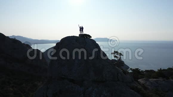 一对青年男女爬上了一座高山欣赏着美丽的黑海和天空视频的预览图