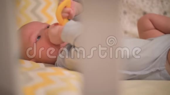 小新生婴儿躺在婴儿床上啃着玩具视频的预览图