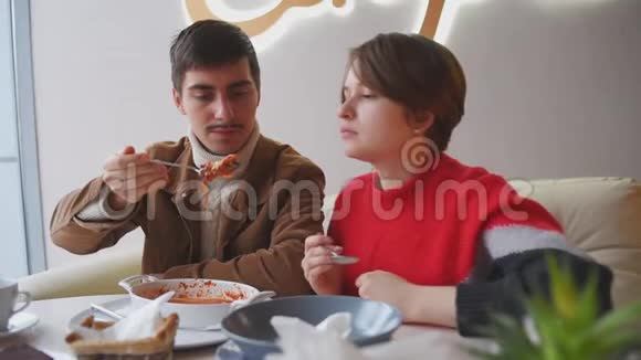一男一女在餐厅吃午饭一对年轻夫妇正在咖啡馆里吃饭视频的预览图