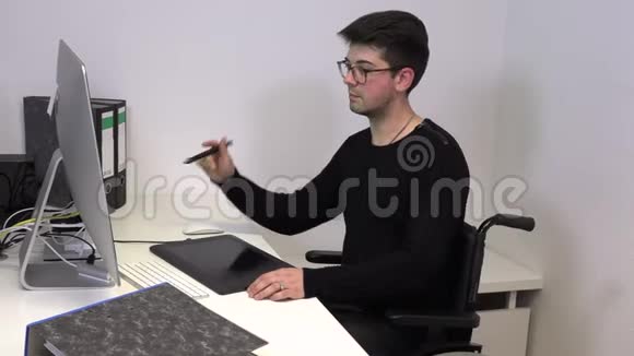 坐轮椅的商人在电脑前工作的年轻人视频的预览图
