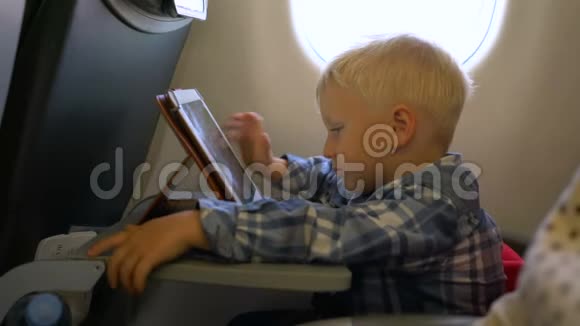 坐飞机玩平板电脑的小男孩视频的预览图
