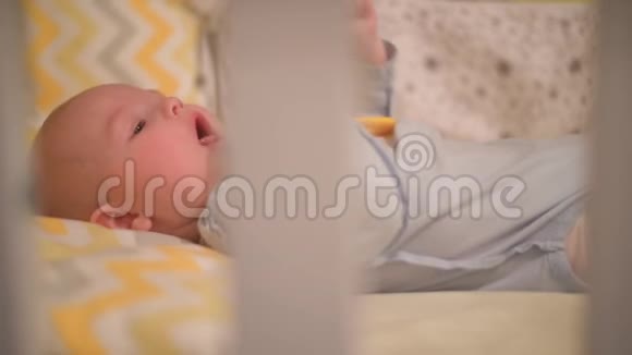 小新生婴儿躺在婴儿床上啃着玩具视频的预览图