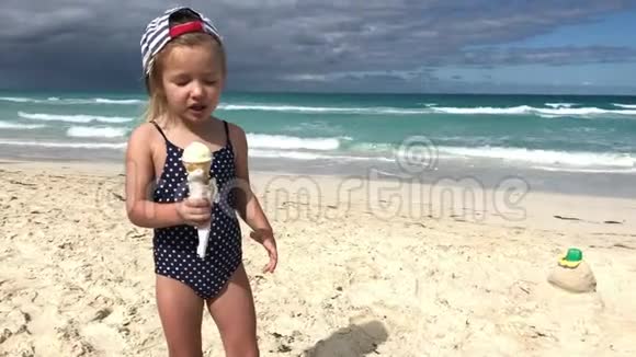 穿泳衣的小女孩在海边吃冰淇淋视频的预览图