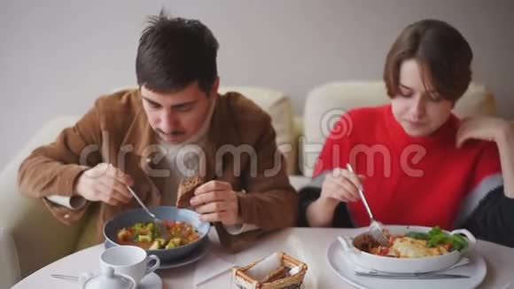 一男一女在餐厅吃午饭一对年轻夫妇正在咖啡馆里吃饭视频的预览图