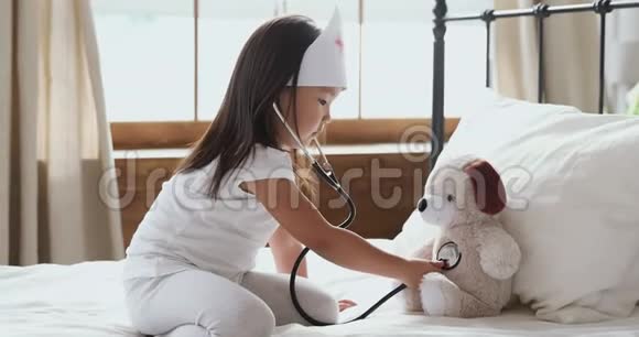 可爱的亚洲小女孩在用听诊器玩护士听力玩具视频的预览图