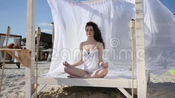 女孩在莲花的位置在平房在热带岛屿放松夏天风发白布阳光明媚视频的预览图