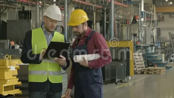 两个戴着安全帽的人在工厂车间工作视频的预览图