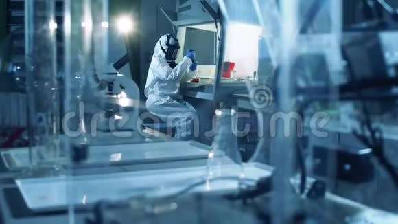 一个穿着危险品服的工人在实验室进行测试冠状病毒COVID19概念视频的预览图
