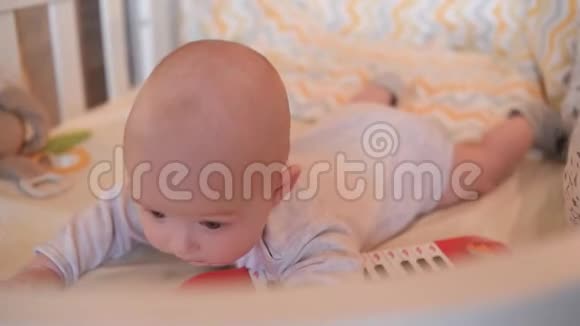 一个漂亮的婴儿躺在婴儿床上玩玩具视频的预览图