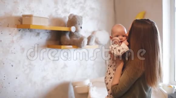 妈妈和笑的孩子玩妈妈手里拿着一个微笑的婴儿视频的预览图
