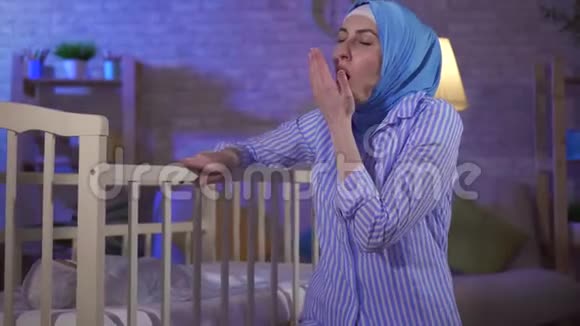 疲惫的画像穆斯林年轻女子是托儿所床边的母亲视频的预览图