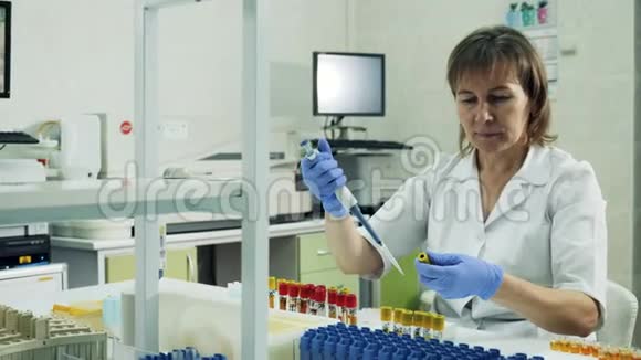 女实验室工作人员正在试管间转移生物样本视频的预览图