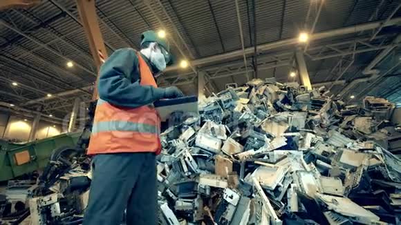一个有工人的垃圾场单位的办公机器碎片视频的预览图