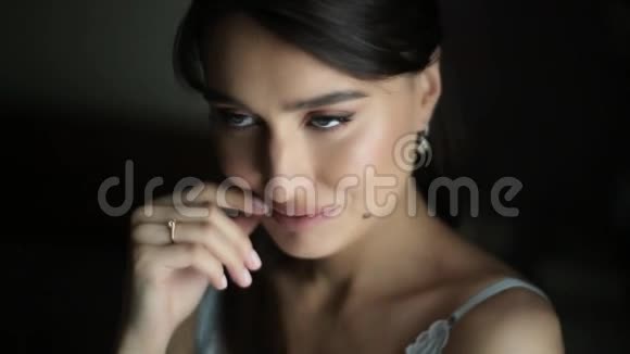 一位穿着优雅睡衣的漂亮性感女士看着相机微笑着用手捂住嘴唇模型视频的预览图