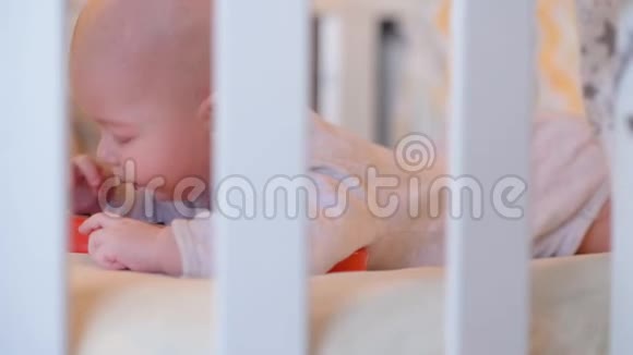 一个漂亮的婴儿躺在婴儿床上玩玩具视频的预览图