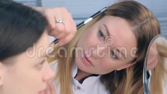美容师为美容诊所的年轻女性做修眉手术视频的预览图
