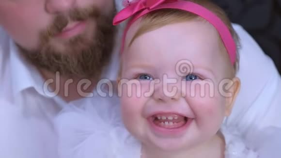 一岁的女婴生日时和爸爸看着镜头微笑的肖像视频的预览图