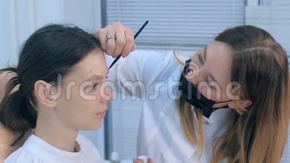 美容师在涂饰前对女性眉毛进行刷纹视频的预览图