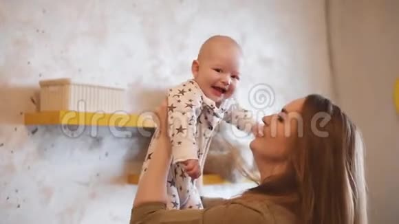 妈妈和笑的孩子玩妈妈手里拿着一个微笑的婴儿视频的预览图