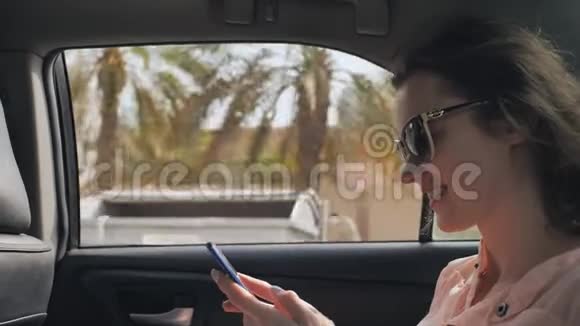 一个坐在移动车里的女孩正在手机上输入一条信息迪拜城视频的预览图