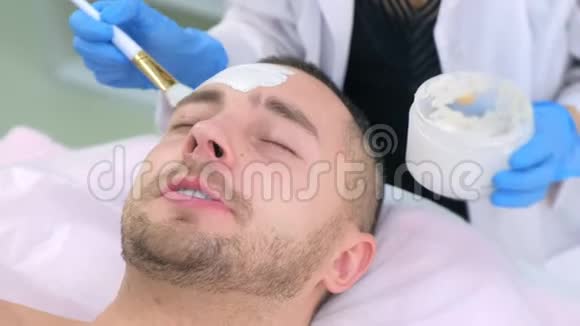 美容医生在美容诊所用白色面膜敷脸特写视频的预览图