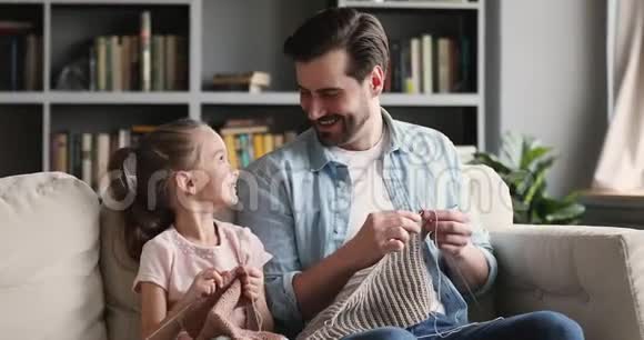 快乐的小父亲快乐地教小女儿编织针视频的预览图