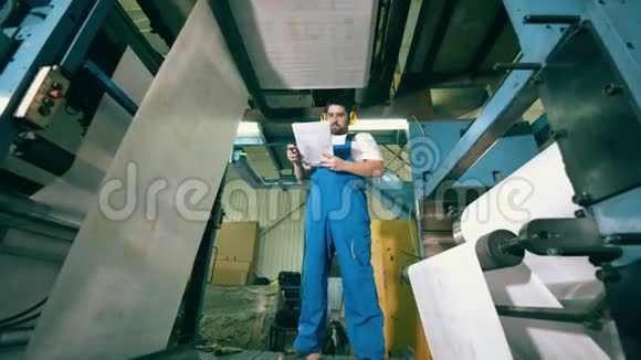 男工程师站在卷纸机下视频的预览图