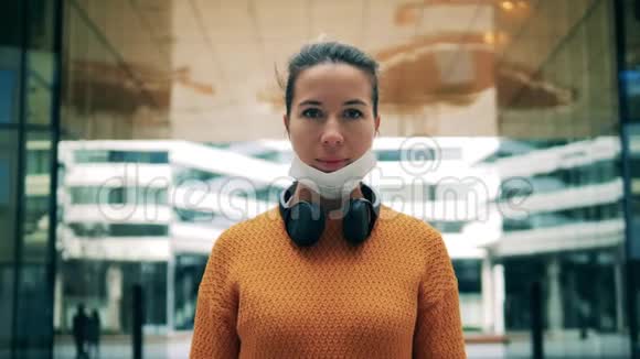 一位戴着医用口罩耳机的女士的正面景色视频的预览图