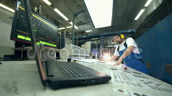 头戴式耳机的男性施工人员正在一个工业设备上进行布局视频的预览图