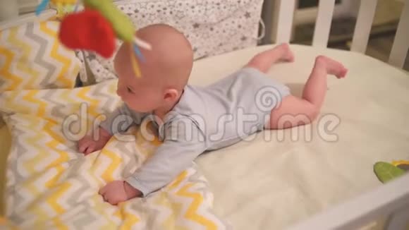 小婴儿趴在家里的婴儿床上视频的预览图