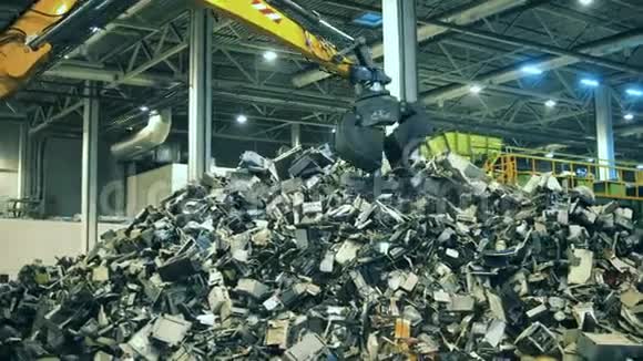 电子垃圾回收厂有缺陷的电子产品碎片被装载机抓住视频的预览图