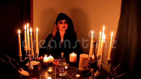 女算命师在黑暗的房间里变戏法用手指指点蜡烛在一张圆形的密桌上燃烧着视频的预览图