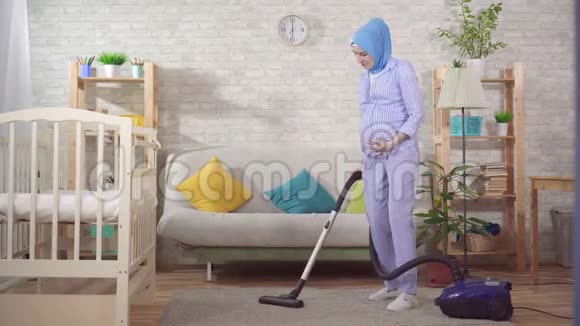 年轻的穆斯林孕妇做家庭作业和吸尘视频的预览图